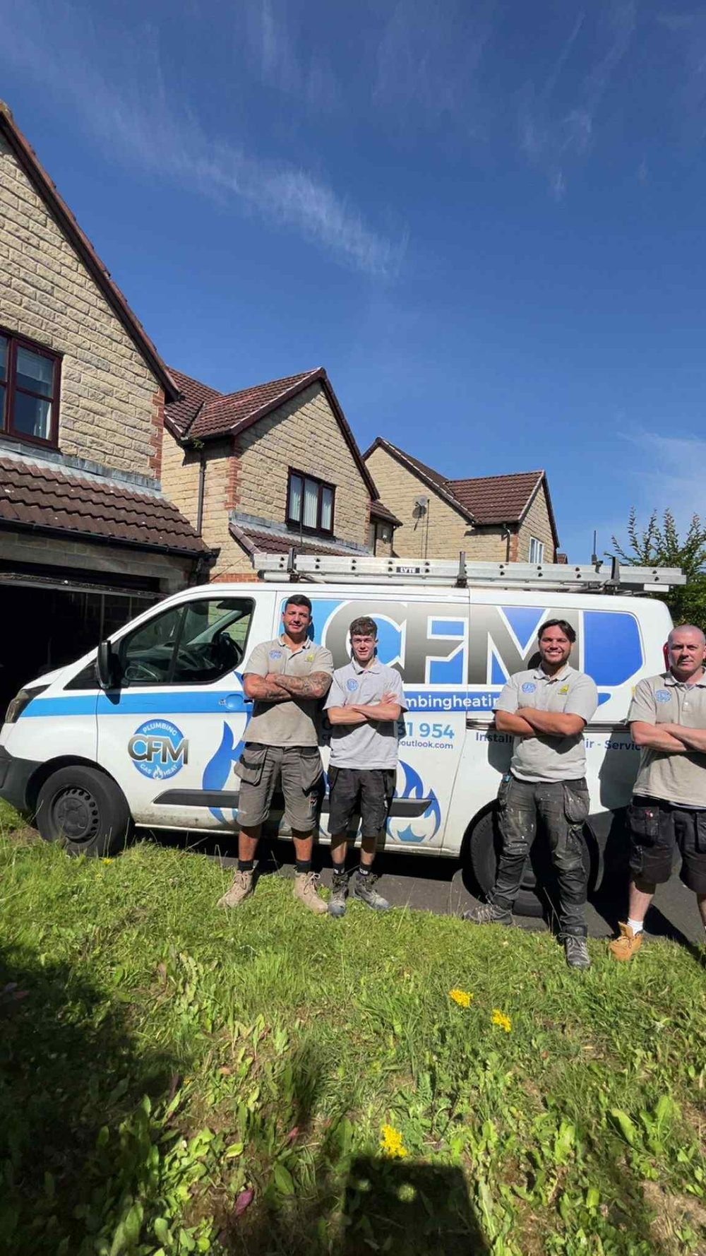 Four members of the CFM team standing in front of a CFM van