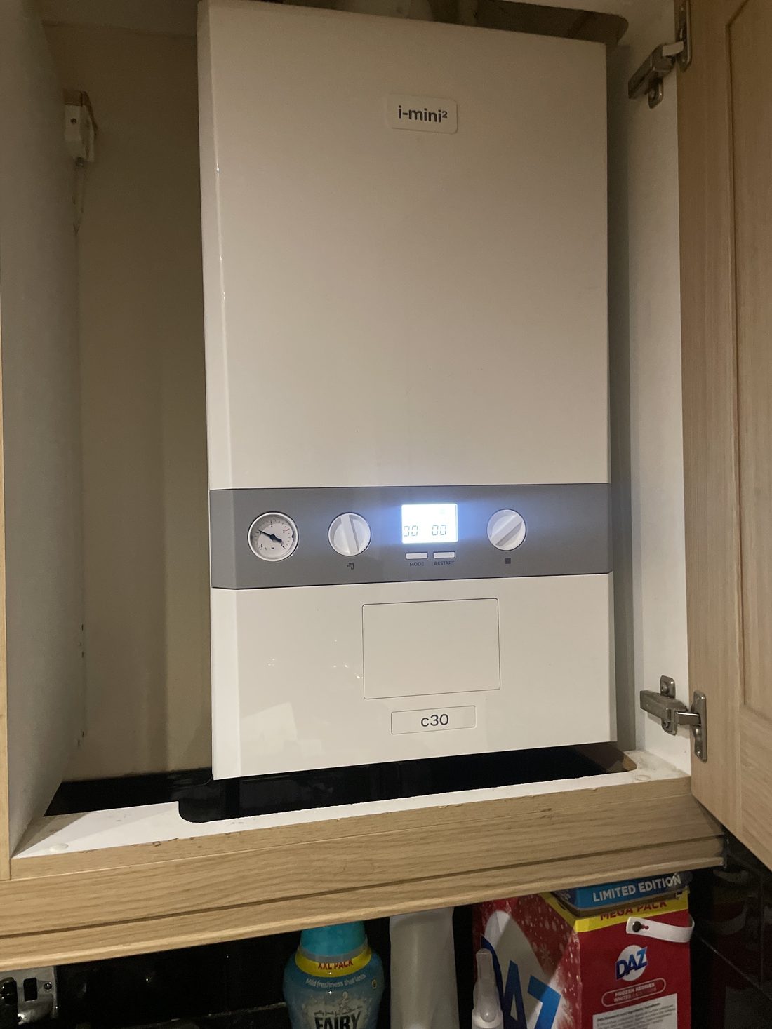 A boiler fitted inside a kitchen cupboard